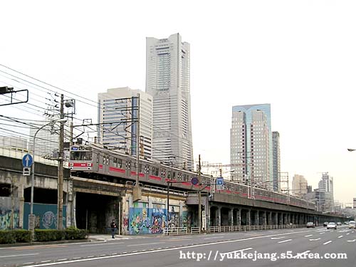 横浜の高層ビルを背景に走る東横線